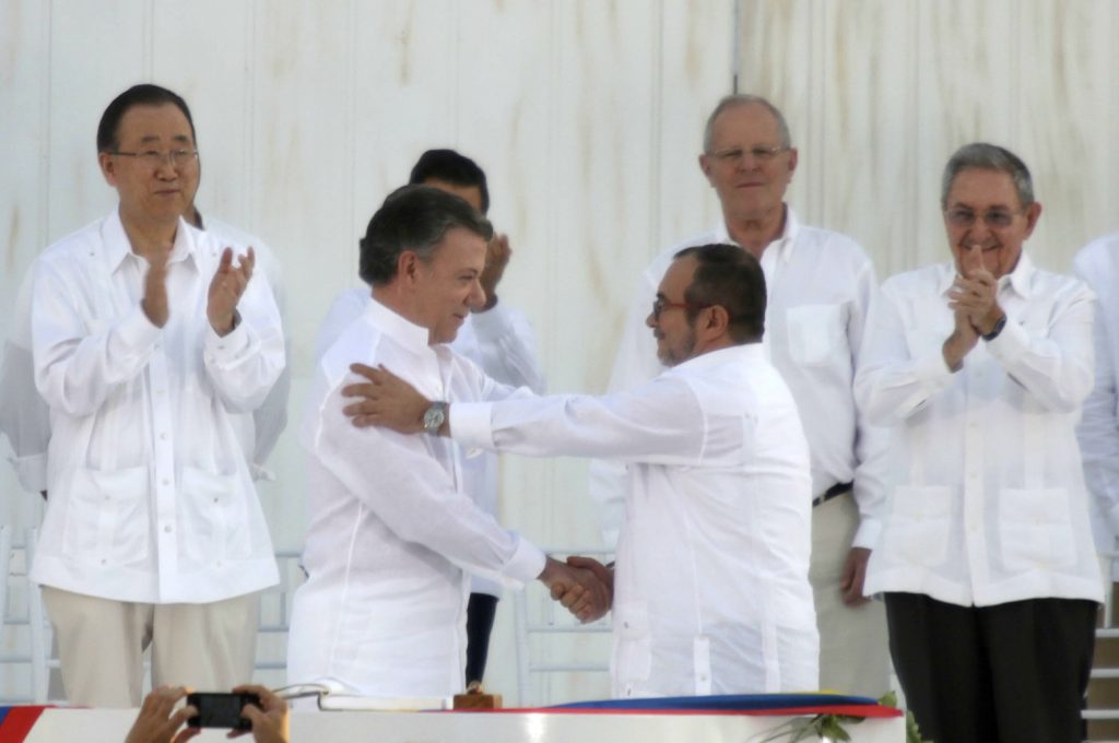 O presidente da Colômbia, Juan Manuel Santos, e o líder das FARC, Rodrigo "Timochenko" Londono Echeverri, apertam as mãos depois da assinarem um histórico acordo de paz