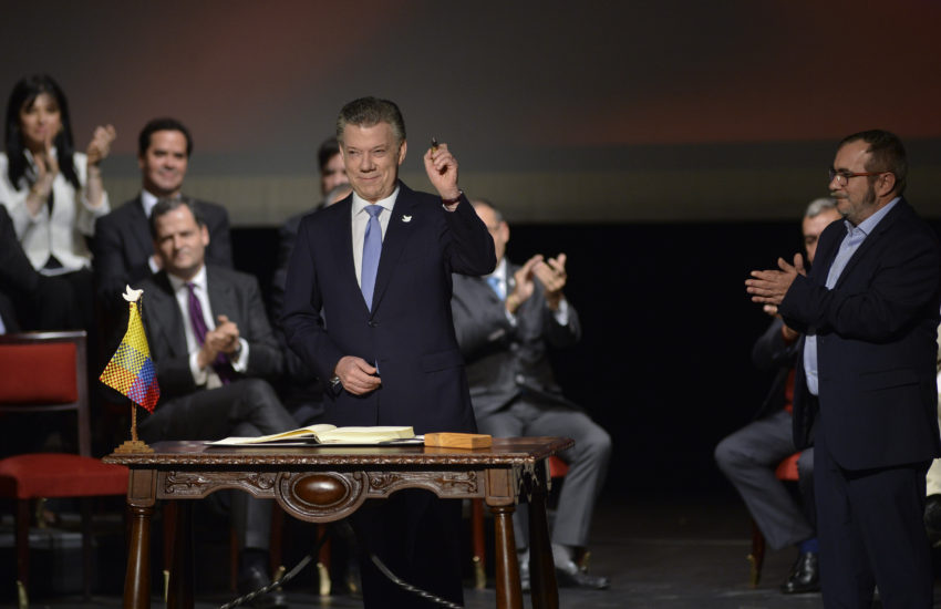 O Presidente da Colômbia, Juan Manuel Santos, assina o acordo de paz com as FARC, numa cerimónia no Teatro Colón de Bogotá.