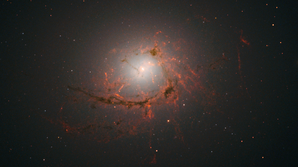 A NGC 4696 tem filamentos encaracolados de poeira e hidrogênio ionizado que saem do corpo celeste principal e vão em direção ao espaço