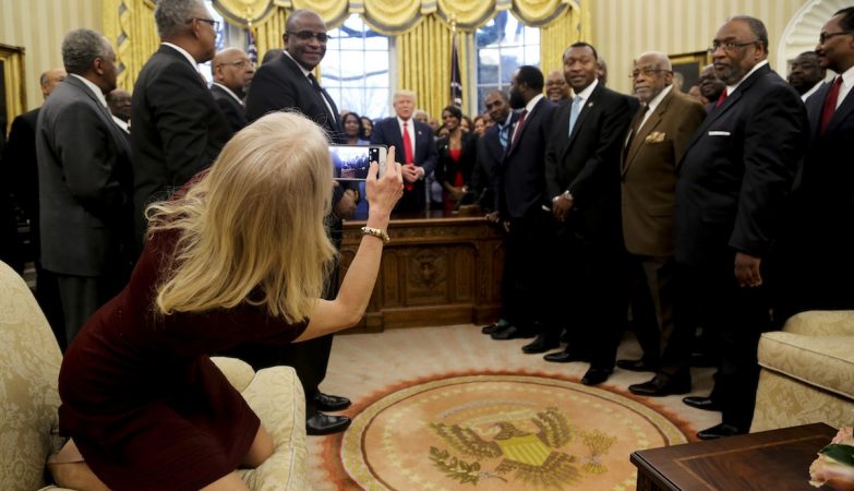Kellyanne Conway, a assessora de Donald Trump, tira uma fotografia com os pés no sofá da Sala Oval da Casa Branca