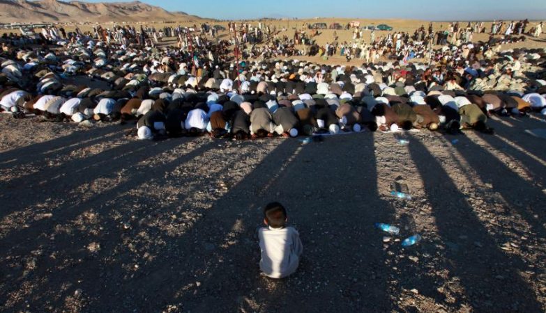 Menino refugiado observa orações