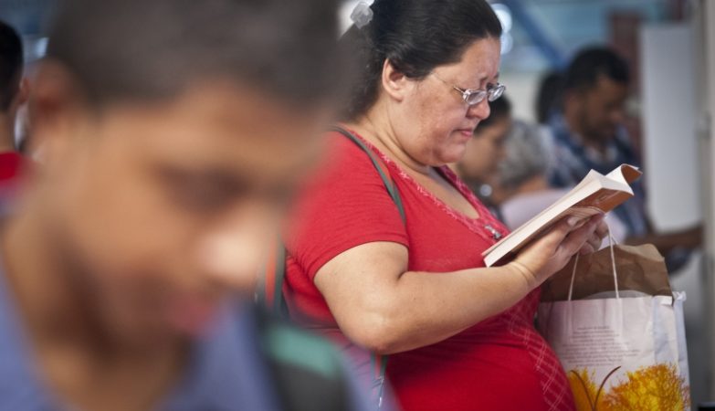 Mulher gorda talvez obesa a ler na feira do livro do metro em São Paulo