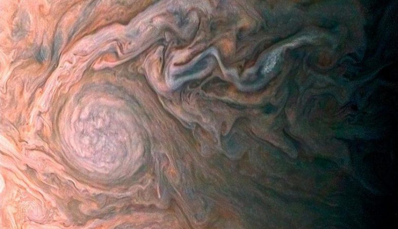 Esta imagem realçada de uma misteriosa mancha escura em Júpiter parece revelar uma “galáxia” de tempestades turbulentas